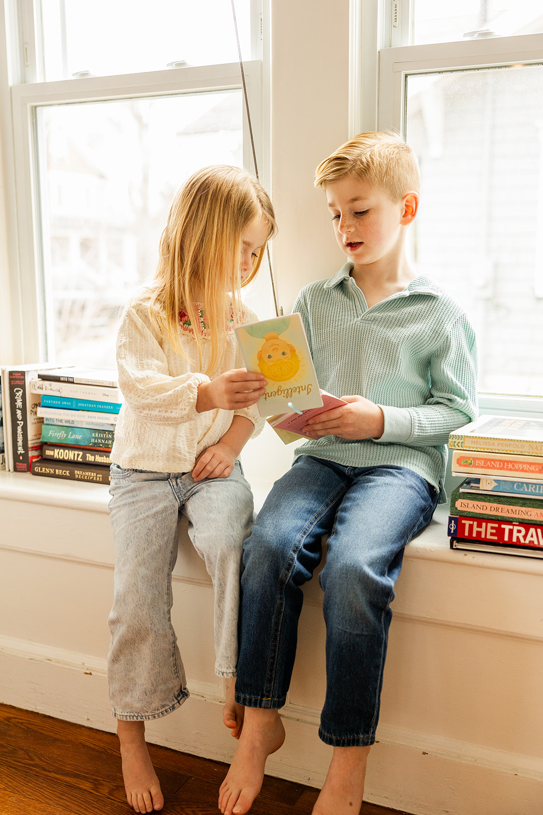 Siblings sharing affirmation cards by the window